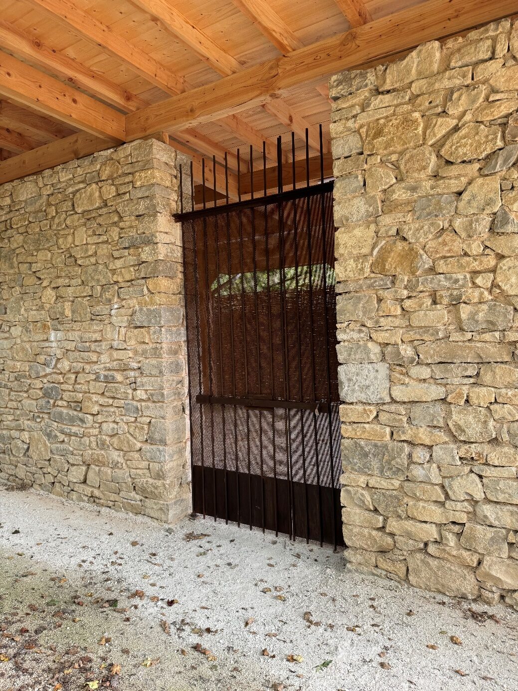Porte en fer forgé sur mur de pierre