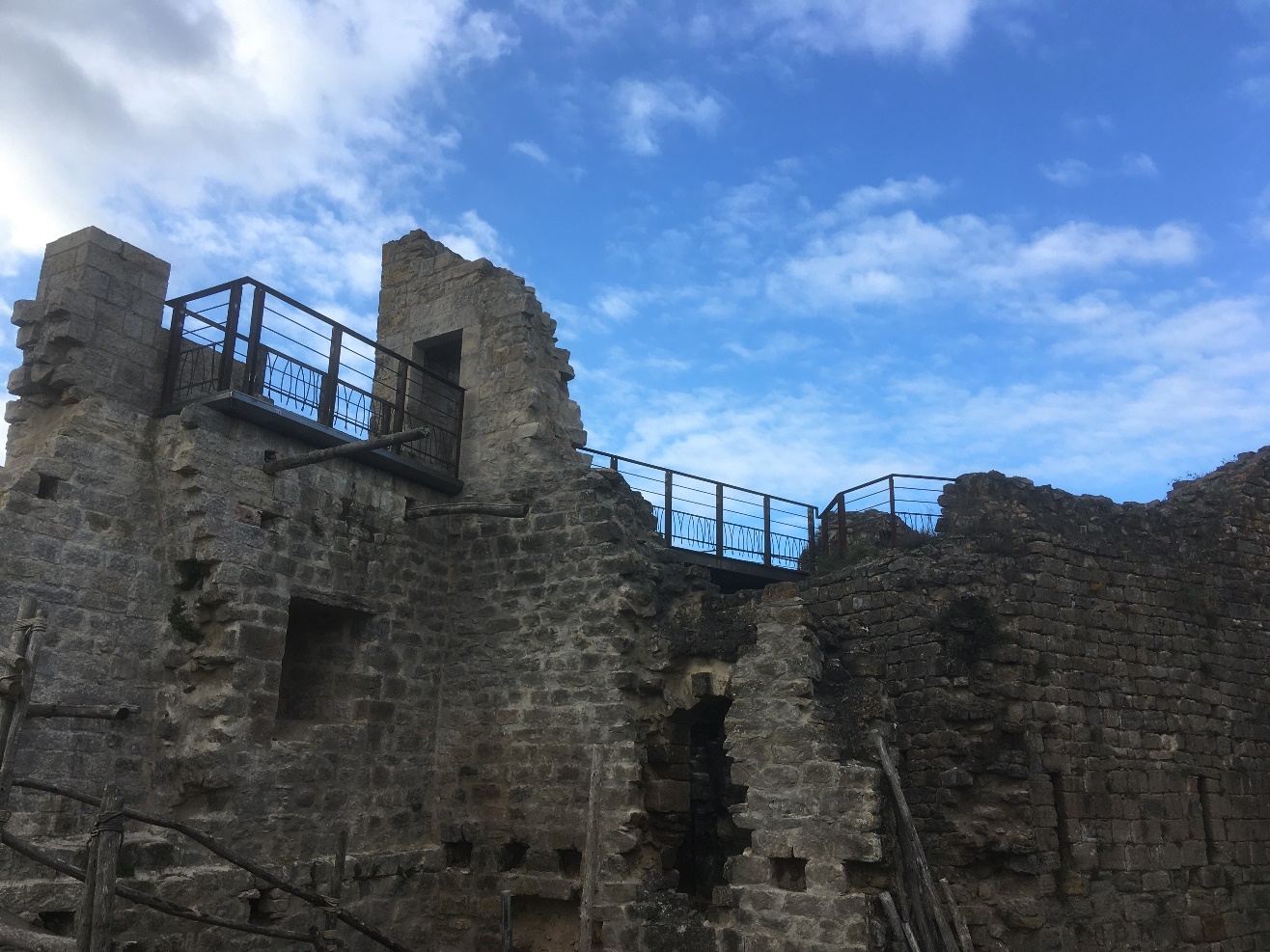 Vieux château en pierre avec rambarde en métal.