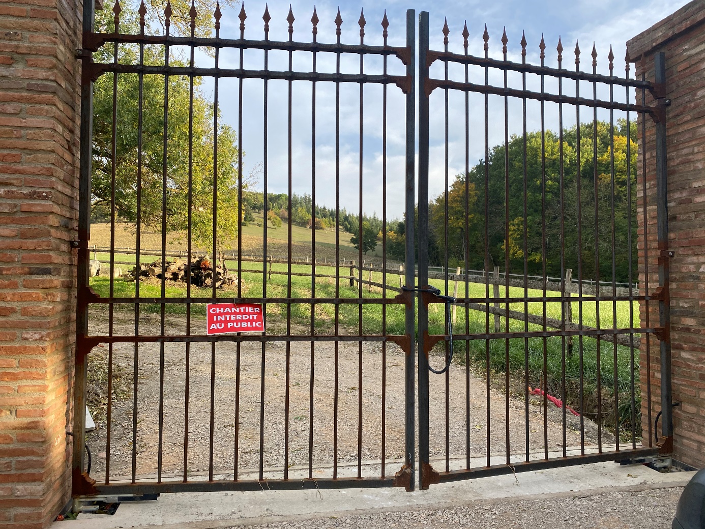 Porte en fer forgé avec panneau d'avertissement