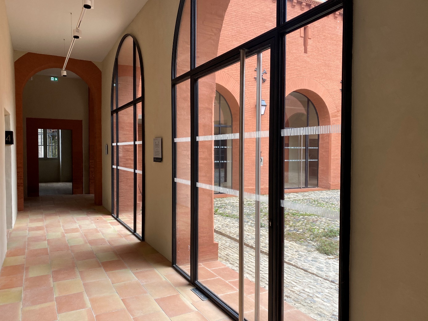 Entrée moderne avec portes vitrées et briques rouges