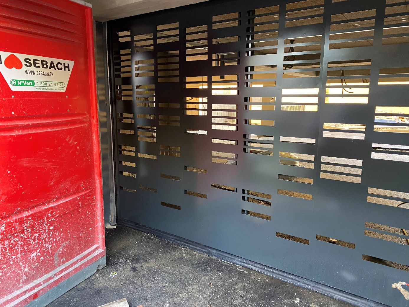 Porte en métal noir avec panneaux perforés