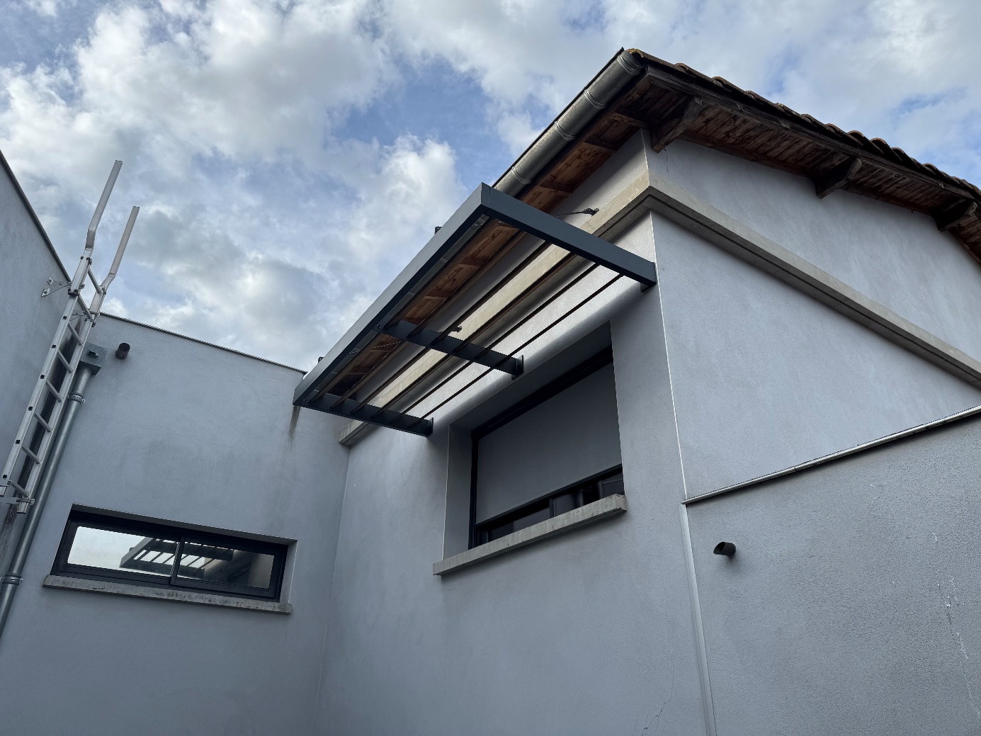 Fenêtre avec auvent sur bâtiment gris