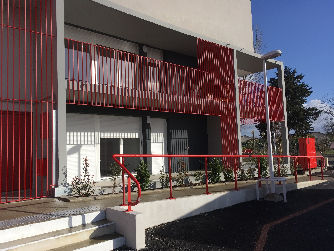 Bâtiment moderne avec rambarde rouge et fenêtres closes