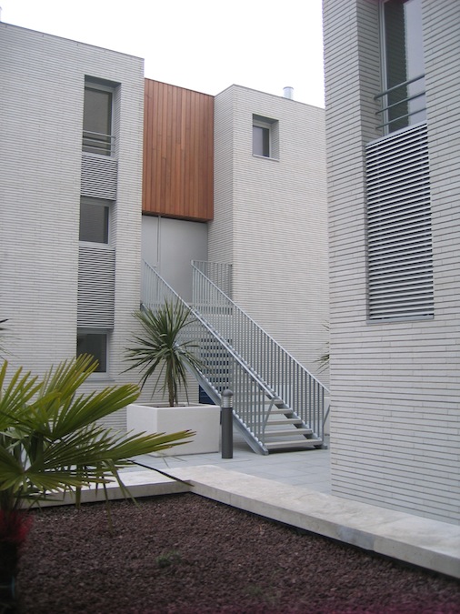 Modern building with metal staircase, plants