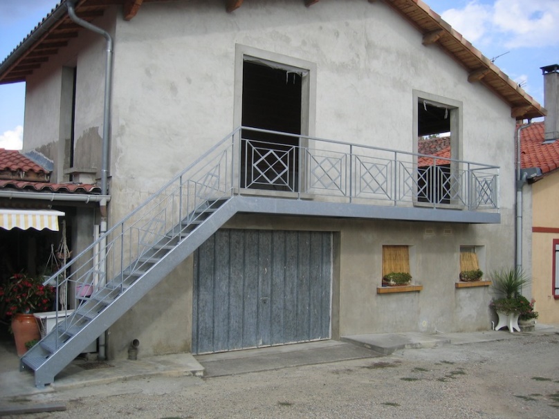Maison avec balcon et escalier métallique