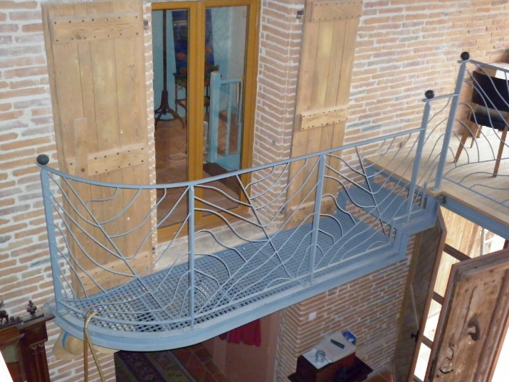 Balustrade en métal, design feuille, escalier en bois, mur de briques