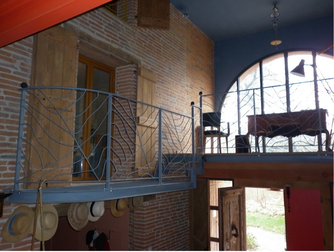 Balustrade en métal, fenêtres en arc, chapeau suspendu