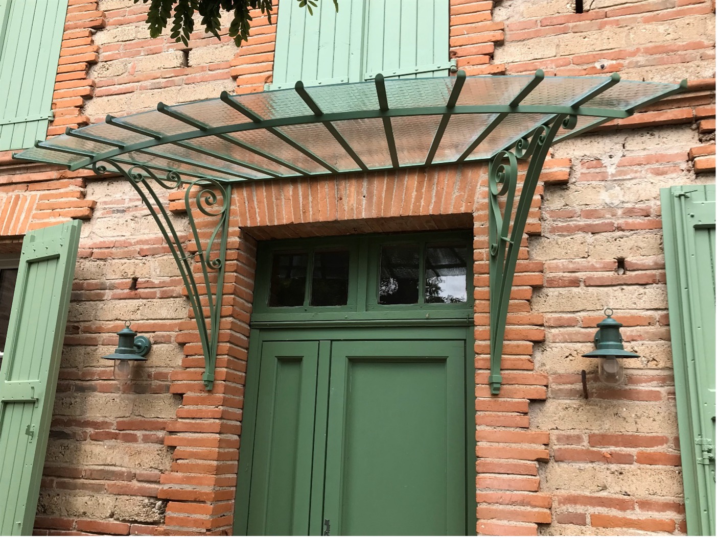 Pergola verte sur porte verte en briques